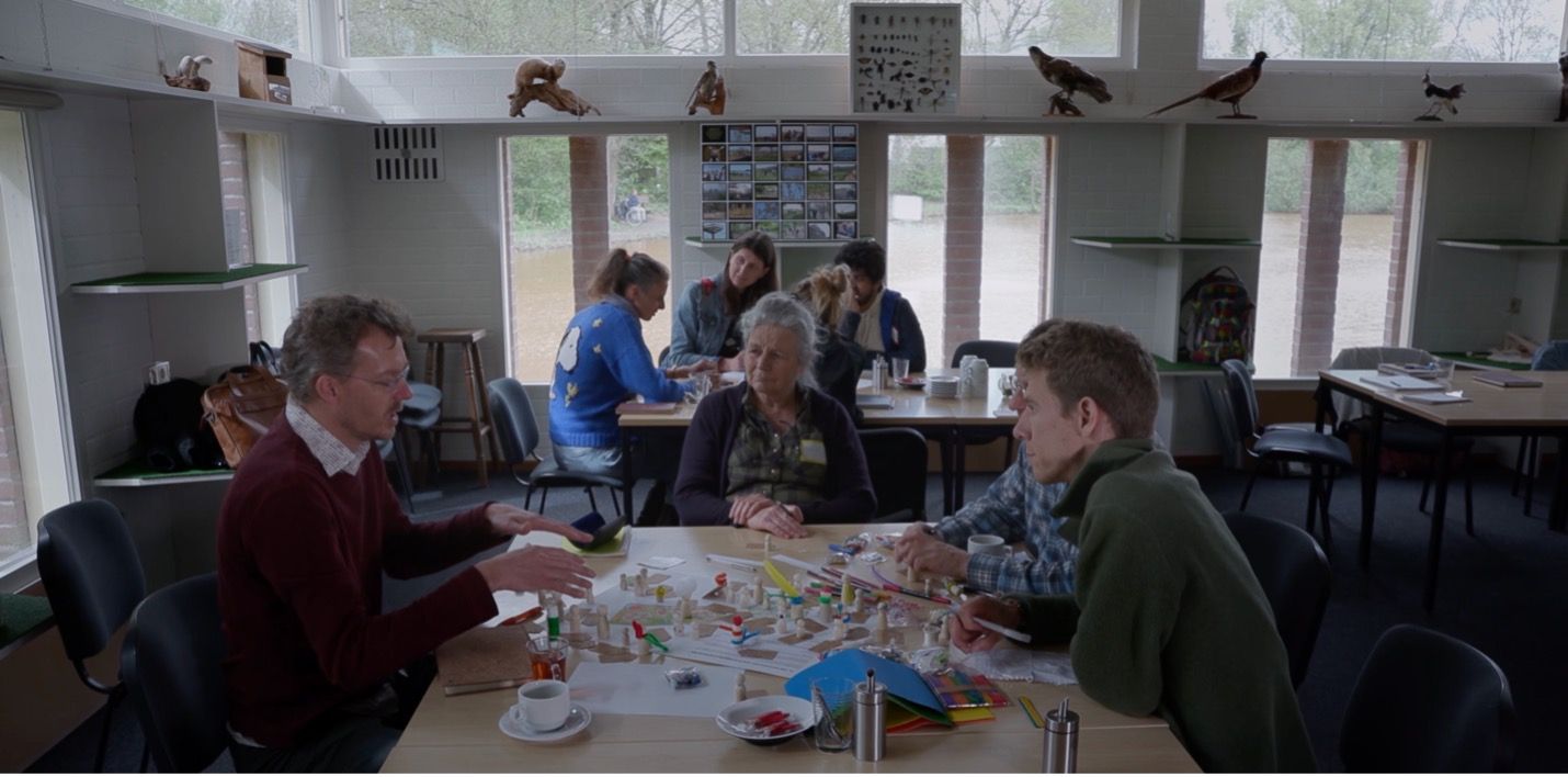 Film Smart Forests yang menampilkan peserta sekolah lapangan yang mendiskusikan rencana dan praktik keanekaragaman hayati di Ecodorp Boekel. Belanda. Mind the Film dengan Smart Forests, 2025.