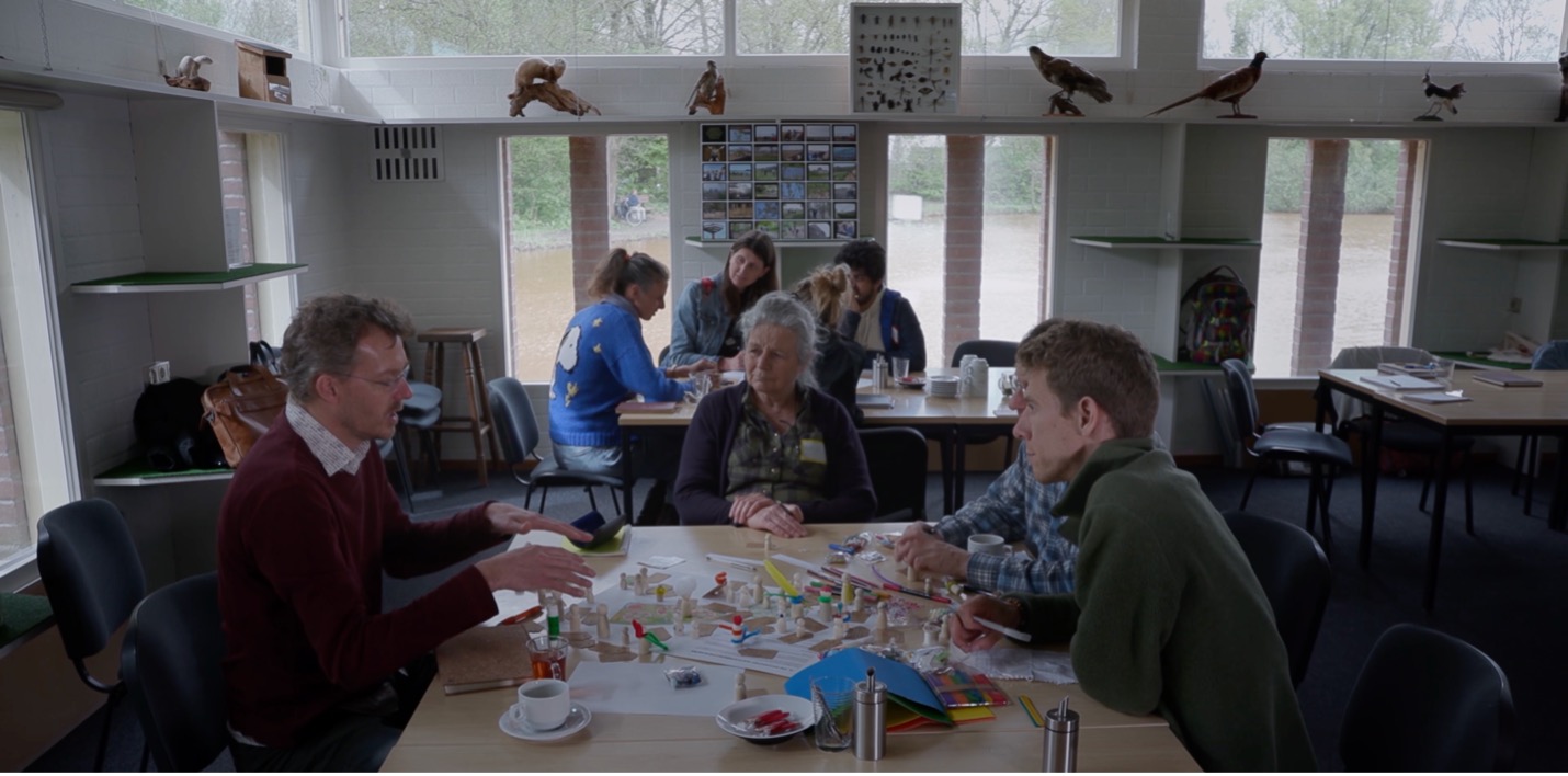 स्मार्ट फॉरेस्ट्स फिल्म में फील्ड स्कूल के प्रतिभागियों को इकोडोर्प बोकेल में जैव विविधता योजनाओं और प्रथाओं पर चर्चा करते हुए दिखाया गया है। नीदरलैंड। स्मार्ट वनों के साथ फिल्म पर ध्यान दें, 2025.